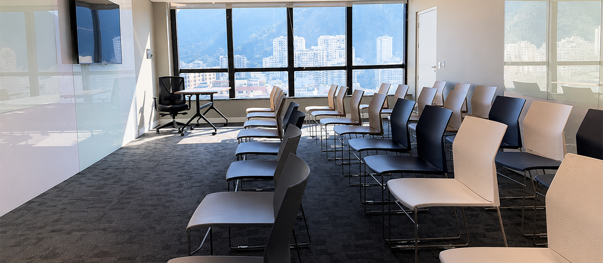 Sala corporativa da TOTVS em Botafogo com cadeiras enfileiradas e vista para o Rio de Janeiro